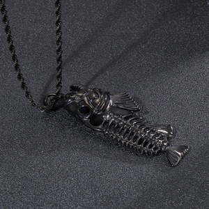 Macro shot of detailed black metal fishbone pendant with vintage texture on a dark surface