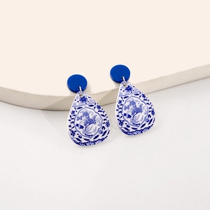 Detail of drop-shaped blue porcelain style earrings with intricate floral patterns
