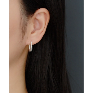 Close-up of S925 sterling silver twisted hoop earrings worn on a model ear