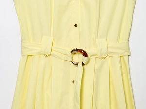 Detailed close-up of the yellow poplin midi dress featuring a buckle belt and button detail
