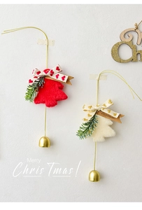 Detail of plush Christmas tree ornaments with bows, pine needles and gold bells