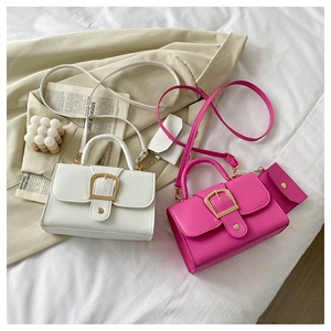 Close-up of candy color crossbody bag with gold buckle and matching small coin purse