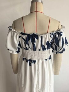 Vue arrière d'une robe fleurie blanche avec manches bouffantes et taille haute sur mannequin