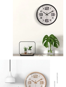Detail view of modern 12 inch wall clocks in black and gold on a minimalist white wall