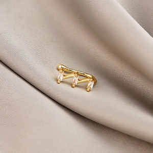 Detail of gold U-shaped non-piercing nose clip with rectangle micro-paved zircons