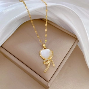 Elegant gold titanium steel necklace with white heart pendant and crystal bow accent