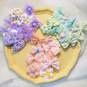 Close-up of colorful bow and flower hair clips in purple, pink, and green sets