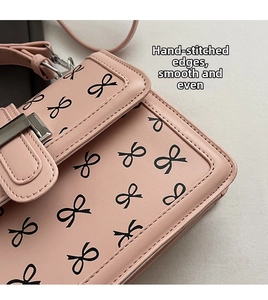 Dettaglio della borsa in pelle PU rosa con cuciture precise e stampa fiocco nero