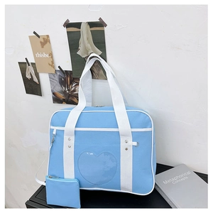 Close-up of sky blue JK travel bag with heart shaped clear window and matching coin pouch