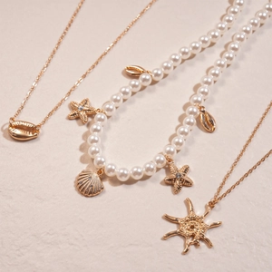 Three-piece gold necklace set with rhinestone starfish and faux pearl shell charms