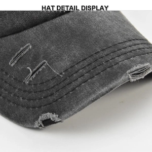 Macro shot of distressed brim on dark grey washed cotton baseball cap with ripped details