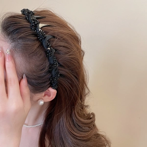 Detail showing black beaded headband with inner teeth for secure hair grip