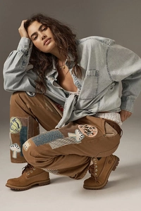 Detail showing vintage patchwork embroidery and stitching on brown cargo pants