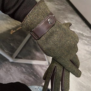 Close-up of men's green herringbone tweed gloves with premium brown leather strap detail