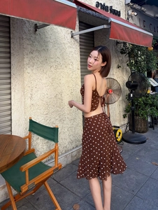 Detail showing the backless halter crop top and polka dot ruffle skirt set in brown