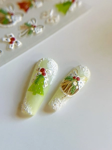 Macro detail of 3D embossed Christmas nail stickers with green trees and red berries