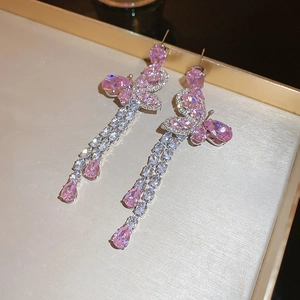 Macro view of pink butterfly drop earrings with zircon tassels on a jewelry tray