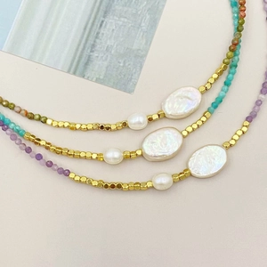 Detailed macro view of irregular freshwater pearls and colorful tourmaline beads on a necklace
