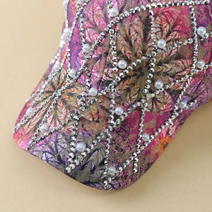 Detailed view of pink floral baseball cap with sparkling rhinestones and pearls
