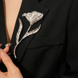 Elegant silver tulip flower brooch with pleated silk texture on a black suit lapel