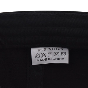 Macro detail of 100% cotton inner lining and care label on the black baseball cap