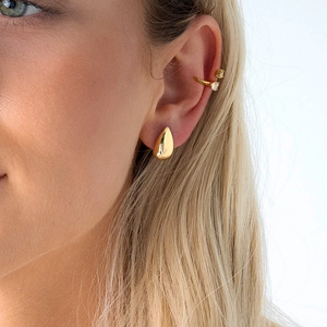 Boucles d'oreilles goutte dorées et manchette d'oreille cœur zircone sur un modèle
