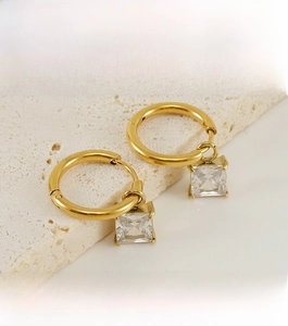 Detail of 18K gold earrings featuring a square zircon with manual micro-inlay craftsmanship