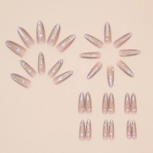 Close-up of long almond cat-eye press-on nails with silver star patterns and rhinestones