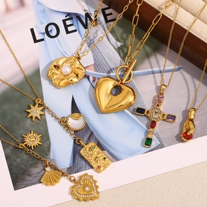 Close-up of vintage 18K gold plated cross and heart pendants on a brand magazine