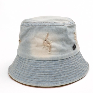 Detail of light blue washed denim bucket hat with distressed holes and metal buckle