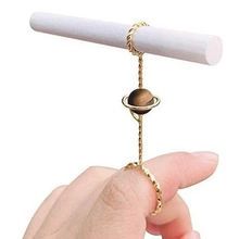 Close-up of golden rose-themed smoking ring holder with brown planet bead detail on finger