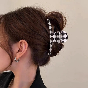 Close-up of checkered pattern hair claw clip on model hair with acetate texture