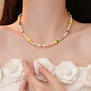 Vue détaillée de perles baroques d'eau douce multicolores sur un collier en acier titane