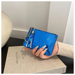 Detail of royal blue crocodile pattern coin purse with tassel and gold keychain