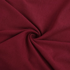 Vue détaillée de la texture du tissu en maille bordeaux doux et du drapé