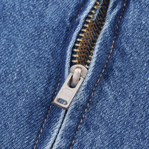 Detailed close-up of premium YKK metal zipper on durable blue denim fabric dress