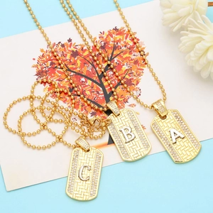 Detailed close-up of golden alphabet pendants A B C with inlaid white zircons