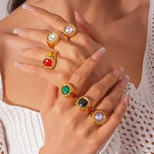 Detail shot of vintage gold rings featuring colorful square zircon stones on fingers