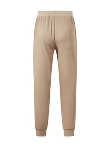Detail of khaki waffle knit men's pants featuring elastic waistband and back pocket