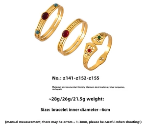 Detail of vintage gold plated titanium steel bangles with red agate and turquoise stones