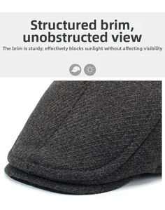 Détail de la visière rigide d'une casquette plate en tweed gris foncé avec motif à chevrons