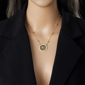 Detail of vintage gold necklace with turquoise pendant and beads worn on model