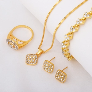 Detail of gold-plated geometric jewelry set featuring clear rhinestones on square charms