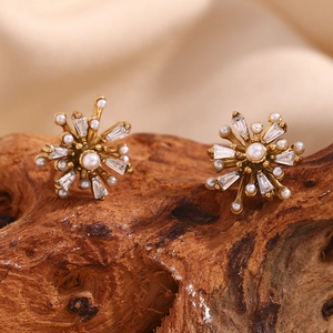 Detailed macro view of 18K gold starburst earrings with white pearl and zircon accents