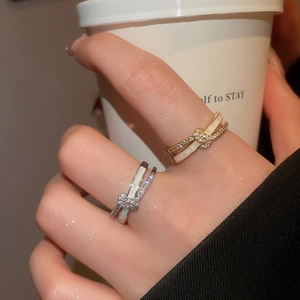 Detailed view of 18k gold and silver crossover rings with zircon and shell inlay