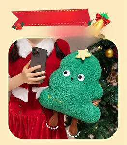 Macro detail of plush green Christmas tree pillow with Be happy embroidery and star topper