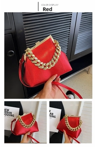 Detail view of red metallic patent leather handbag with thick gold chain handle and strap
