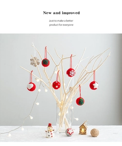 Close-up of festive wool felt Christmas balls with snowflake patterns on decorative branches
