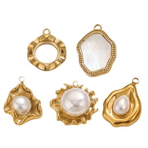 Five vintage gold stainless steel charms with pearls and shells on white background