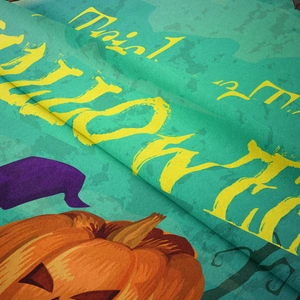 Close-up of Halloween tapestry fabric showing textured print with pumpkin and wizard hat